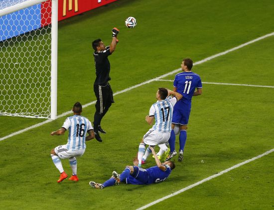 Argentina's goalkeeper Sergio Romero makes a save past Bosnia's Edin Dzeko (right)