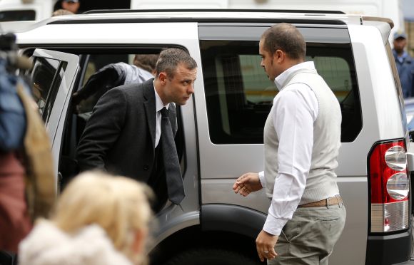 Olympic and Paralympic track star Oscar Pistorius (L) arrives ahead of his trial for the murder of his girlfriend Reeva Steenkamp 
