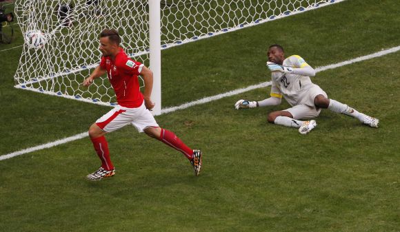 Switzerland's Haris Seferovic (left) scores past Ecuador's Alexander Dominguez during their 2014 World Cup Group E match at the Brasilia national stadium