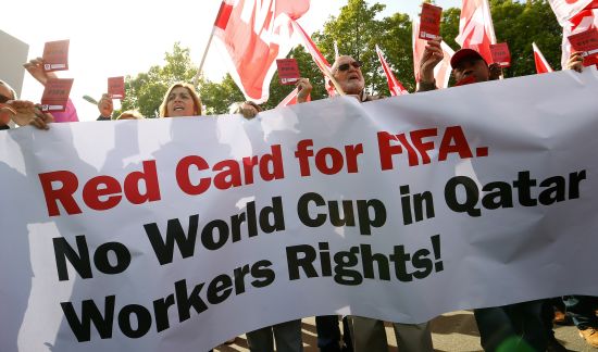 Members of the Swiss UNIA workers union display red cards and shout slogans during a protest in front of the headquarters of soccer's international governing body FIFA in Zurich 