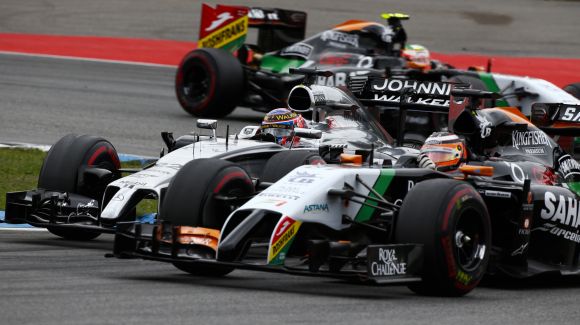 Force India Formula One driver Nico Hulkenberg of Germany (R) and McLaren Formula One driver Jenson Button of Britain (L) drive through a corner during the German F1 Grand Prix