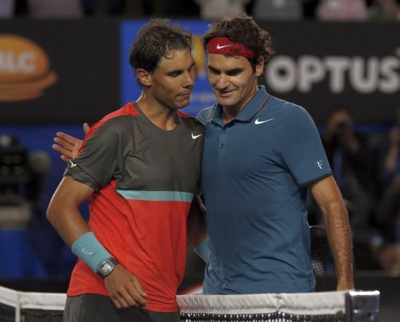 Rafael Nadal (L) of Spain and Roger Federer of Switzerland hug at the net, after Nadal won their men's singles semi-final match at the Australian Open 2014 tennis tournament 