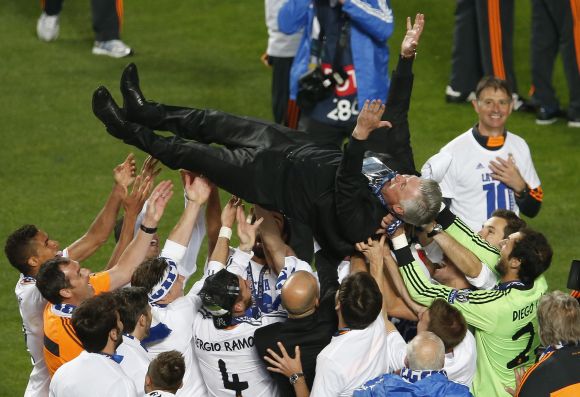 Real Madrid's coach Carlo Ancelotti is thrown in the air by his team as they celebrate after defeating Atletico Madrid.