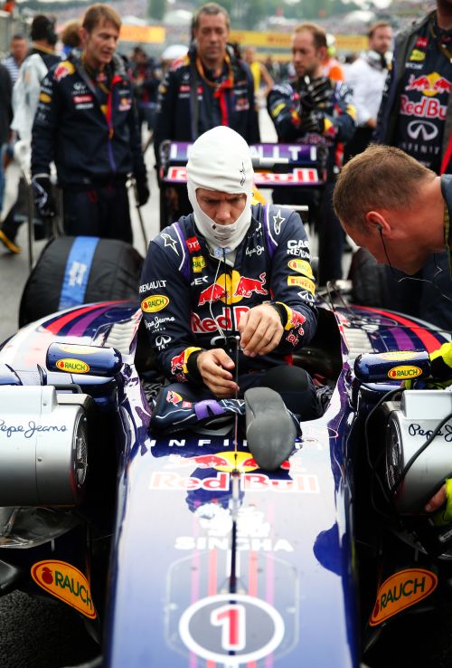 Sebastian Vettel of Germany and Infiniti Red Bull Racing gets into his car before the Hungarian Formula One Grand Prix 