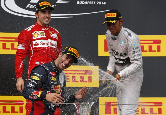 Winner Red Bull Formula One driver Daniel Ricciardo of Australia is splashed with champagne by second placed Ferrari Formula One driver Fernando Alonso of Spain (L) and third placed Mercedes Formula One driver Lewis Hamilton of Britain (R) 