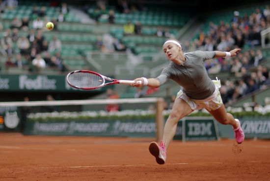 Anna Schmiedlova of Slovakia stretches to hit a return to Venus Williams.