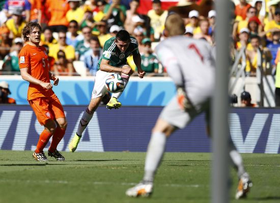 Mexico's Hector Herrera (C) tries to score past Daley Blind of the Netherlands