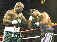 James Toney (L) connects on former heavyweight champion Evander Holyfield in the third round.