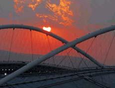 sun setting over the Olympic Stadium's roof