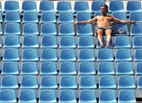 A lone spectator watches the men's singles first round Olympic tennis tournament match