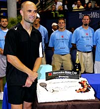 Andre Agassi poses with a cake after winning his 800th career singles match