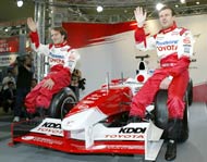 French Formula One driver Olivier Panis (R) and Brazilian Cristiano da Matta of Toyota wave to fans as they sit on Toyota's TF104 car for this season, during a Toyota Formula One fan-oriented event in Tokyo February 29, 2004. 