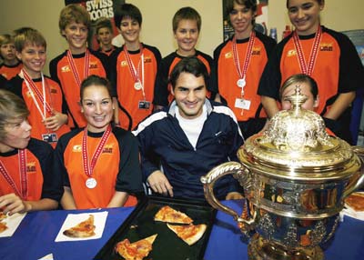 Roger Federer serves pizza to ball kids