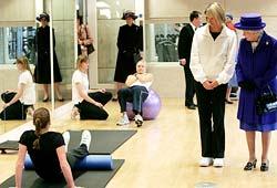 Britain's Queen Elizabeth II (R) inspects a gym during her visit to the new National Tennis Centre