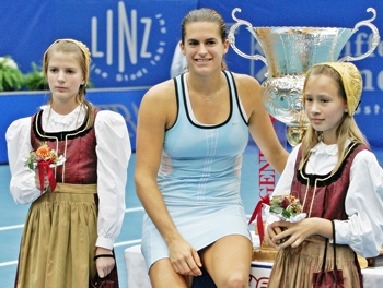 Mauresmo poses with girls in traditional outfits after winning the Generali Open in Linz