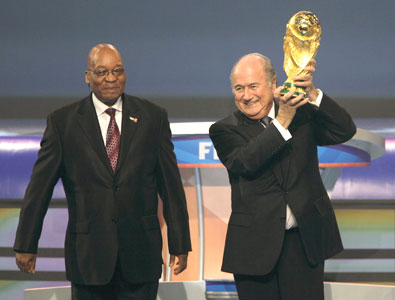 South African President Jacob Zuma watches as FIFA president Blatter holds up the World Cup trophy before the 2010 World Cup draw in Cape Town on Friday