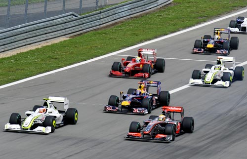Brawn GP driver Rubens Barrichello of Brazil (left) leads the pack into the first turn ahead of McLaren's Lewis Hamilton