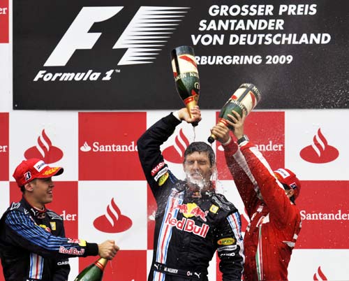 Webber is sprayed with champagne by team-mate Vettel (left) and Massa (right)