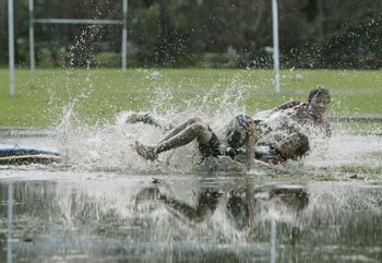 Boys play rugby on a flooded pitch in Sydney