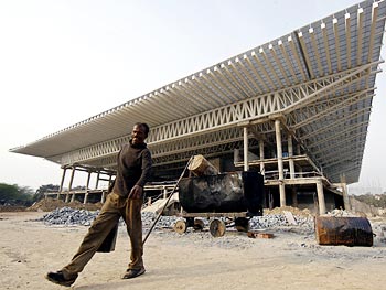 A labourer walks at the Thyagaraja Sports Complex, one of the venues for the Commonwealth Games 2010, in New Delhi.