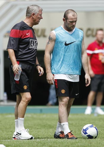 Manchester United's manager Alex Ferguson (left) and Wayne Rooney talk during a training session in Seoul on Thursday