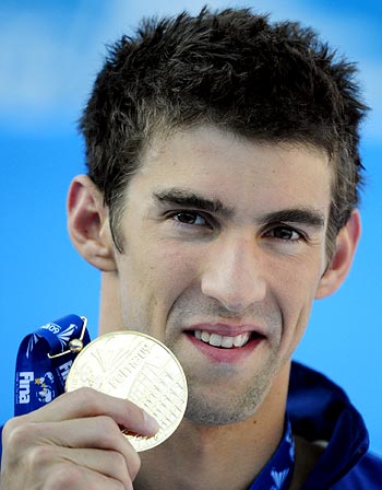 Michael Phelps celebrates on the podium