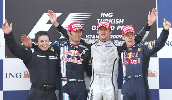 Peter Bonnington, a member of the Brawn-Mercedes team, 2nd placed Mark Webber, winner Jenson Button and 3rd placed Sebastian Vettel on the podium