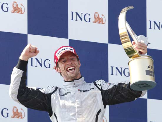 Jenson Button of Britain celebrates on the podium