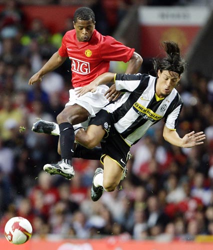 Manchester United's Patrice Evra (left) clashes with Mauro Camoranesi of Juventus