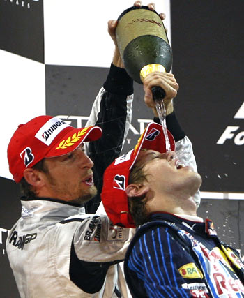 Red Bull's Sebastian Vettel and Brawn GPs Jenson Button (left) celebrate their podium finish in Abu Dhabi on Sunday
