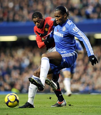 Manchester United's Patrice Evra (left) challenges Didier Drogba