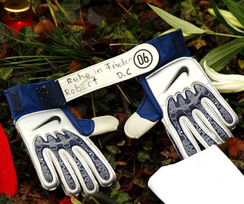 Soccer gloves with the inscription 'Rest in Peace, Robert' lie at a condolence area outside the headquarters of soccer team Hanover 96