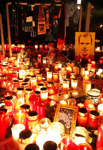 Soccer scarfs are fixed beside lit candles in memory of German goalkeeper Robert Enke outside the stadium of Hanover 96
