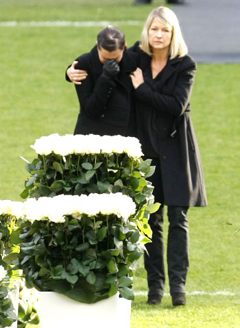 Robert Enke's wife Teresa (left) is comforted by an unidentified woman during the memorial service on Sunday