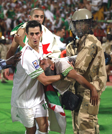 Algeria's Rafik Saifi (left) helps carry an injured Algerian fan after Algeria won their 2010 World Cup qualifying play-off match against Egypt in Khartoum. Algeria became the last African nation to qualify for the 2010 World Cup finals on Wednesday, beating Egypt 1-0 in a bruising playoff in neutral Sudan