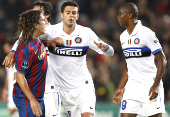 Barcelona's Carles Puyol (left) argues with former team-mate and Inter Milan striker Samuel Eto'o (right) while Thiago Motta tries to seperate them, at Nou Camp in Barcelona on Tuesday