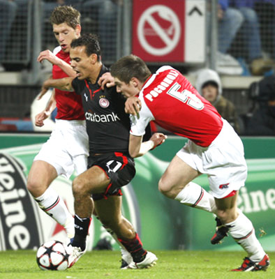 Olympiakos's Jaouad Zairi (centre) is challenged by AZ Alkmaar's Stijn Schaars and Sebastien Pocognoli (right) during their Champions League match on Tuesday