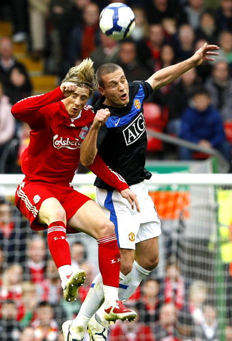Liverpool's Fernando Torres (left) and Manchester United's VIdic are involved in an ariel duel during their Premier League match on Sunday