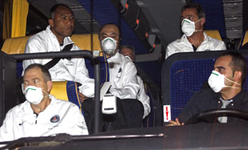 Paris Saint Germain's coach Kombouare (far left, without mask) sits with staff as they leave their hotel in Marignane on Sunday