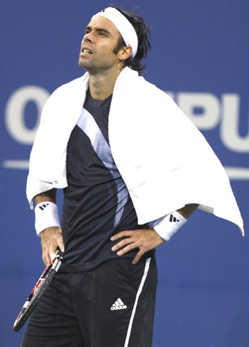 Fernando Gonzalez takes a break, as a brief spell of rain interrupts play, during the first set of his US Open quarter-final tie against Rafael Nadal on Thursday
