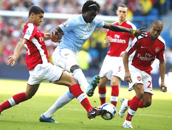 Manchester City's Adebayor is locked in a challenge with Arsenal's Denilson and Clichy