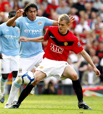 Carlos Tevez tries to get the ball past Man United's Darren Fletcher