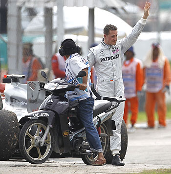 Michael Schumacher of Mercedes waves to the crowds after retiring from the Malaysian Grand Prix on Sunday
