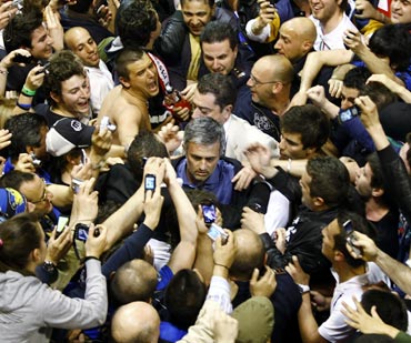 Inter Milan's coach Jose Mourinho (C) is surrounded by fans on his arrival at Malpensa airport