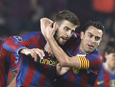 Barcelona's Pique (left) celebrates after scoring with team-mate Xavi