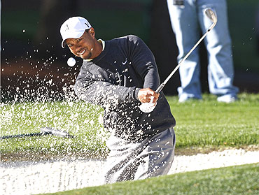 Tiger Woods hits from a sand trap on the sixth hole during a pro-am event before play in the Quail Hollow Championship