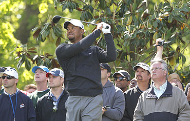 Tiger Woods tees off as the gallery watches on the 15th tee during a pro-am event before play in the Quail Hollow Championship