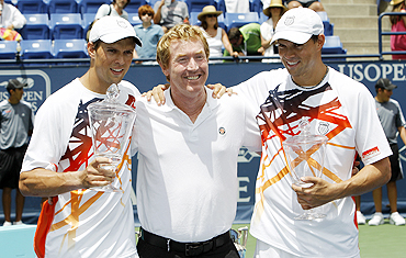 Mike Bryan (left) and Bob Bryan (right) of the US pose with former Australian doubles player Mark Woodforde after their victory over Eric Butorac of the US and Jean-Julien Rojer of Netherlands Antilles on Sunday