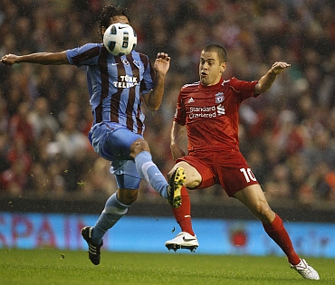Liverpool's Joe Cole challenges Trabzonspor's Selcuk Inan during their Europa League playoff match