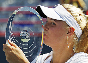 Caroline Wozniacki of Denmark kisses the trophy after defeating Vera Zvonareva of Russia in the rain delayed final at the Rogers Cup tennis tournament in Montreal on Monday